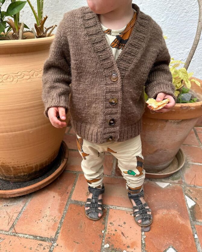 PetiteKnit Eva Cardigan Junior wzór na druty, według którego wykonasz kardigan dziecięcy z wełny Peer Gynt Sandnes Garn. Włóczka wełniana 100% wełna norweska.