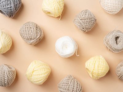 pastel and beige colored yarn wool on beige backdrop, top view flat lay pastel and beige colored yarn wool on beige backdrop, top view flat lay. Knitting pattern